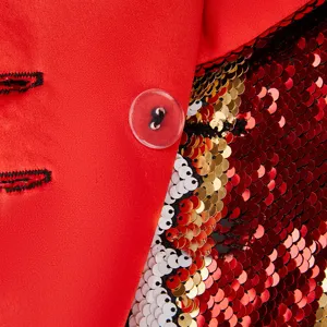Primer plano de detalle de blazer de lentejuelas rojas con botón y tela brillante.