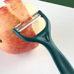 Stainless steel fruit peeler with sharp blade, ergonomic green handle for kitchen use.