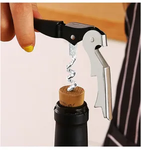 Detailed view of stainless steel waiter corkscrew opening wine bottle in close up.