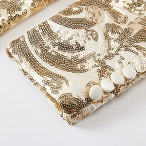 Close-up detail view of men's sequin blazer sleeve cuff with gold embroidery and fabric buttons.