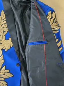 Vista detallada de una chaqueta de traje para hombre con lentejuelas doradas y forro interior.