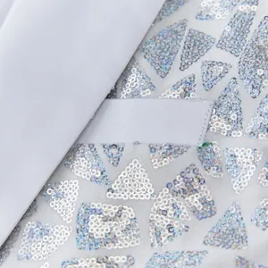 Men's sequin suit jacket detail shot, featuring geometric silver triangle sequins on white fabric.