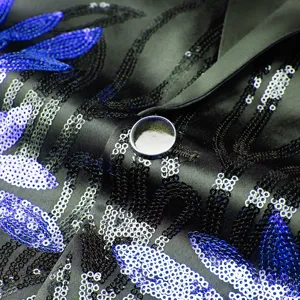 Close-up of men's black sequin blazer detail with blue silver embroidery button.