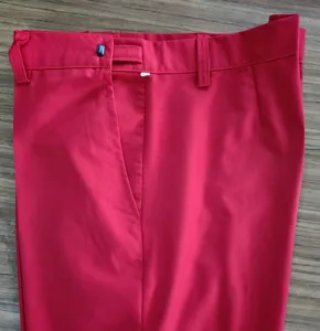 Primer plano del detalle de la cintura de un pantalón de traje rojo con trabillas.