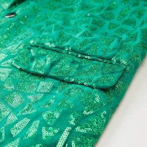 Men's green triangular sequin suit jacket detail showing geometric sparkly fabric.