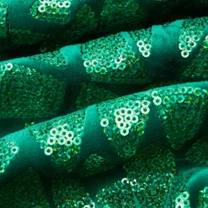 Green velvet fabric detail with sparkling triangular sequins for luxury men suit jacket apparel.