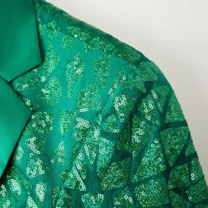 Green sequin blazer shoulder detail showing sparkling triangular patterns and satin lapel fabric.