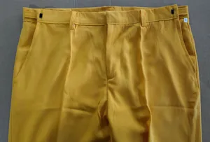 Detalle de pantalón de traje informal amarillo para hombre, tela de gran calidad.