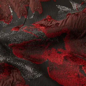Vue macro détaillée d'un tissu jacquard noir et rouge luxueux pour veste de costume.