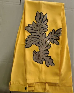 Detalle de pantalón de hombre, amarillo vivo con elegante motivo floral de lentejuelas.