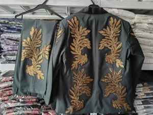 Vista detallada de traje de hombre gris oscuro con brillantes aplicaciones de lentejuelas doradas.