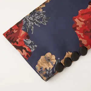 Gros plan detail de la manchette de costume jacquard florale bleu fonce avec quatre boutons noirs.