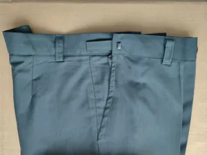 Primer plano de la cintura de los pantalones de hombre verde oscuro con presillas y cremallera.
