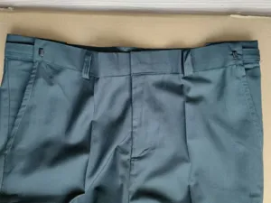 Pantalones de traje formales verde oscuro para hombre con ajustadores laterales.