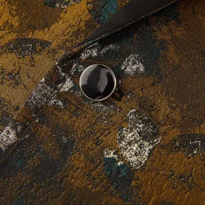 Détail de costume casual rétro jacquard pour homme, tissu métallique chic et bouton noir élégant.