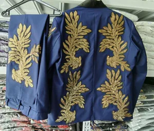 Detalle de aplicacion de lentejuelas doradas del conjunto de chaqueta y pantalon.