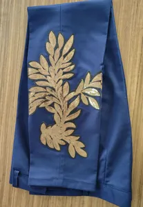Primer plano del detalle de la aplicación de hojas de lentejuelas doradas en pantalón.