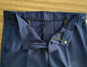 Primer plano de la cintura de un pantalón de hombre azul oscuro con costuras limpias y cierre.