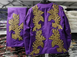 Vista detallada traje morado de hombre con lujosas aplicaciones de hojas de lentejuelas doradas.