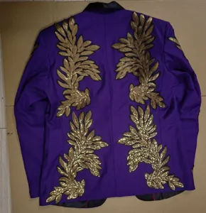 Vista detallada de la chaqueta de traje morada para hombre con aplicaciones de hojas de lentejuelas.
