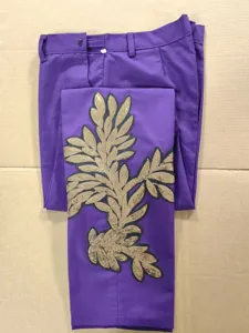 Detalle de pantalón morado para hombre con exquisito bordado de hojas de lentejuelas doradas.