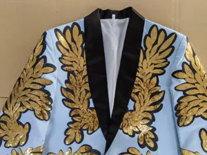 Primer plano de una chaqueta azul para hombre con aplicaciones de lentejuelas doradas.