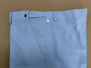 Detalle de cintura de pantalón de traje de hombre azul claro con trabillas y etiqueta.