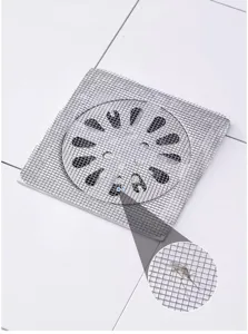 Close-up view of fine mesh floor drain sticker trapping small insects effectively in bathroom.