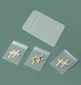 Clear PVC ziplock jewelry storage bags with sparkling cross pendant charms detailed view.