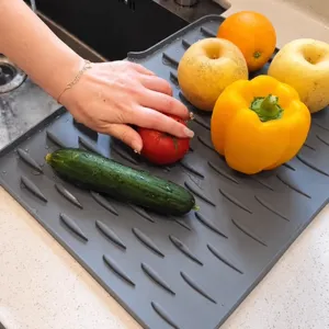 Tappetino scolapiatti in silicone inclinato per cucina, resistente al calore e antiscivolo.