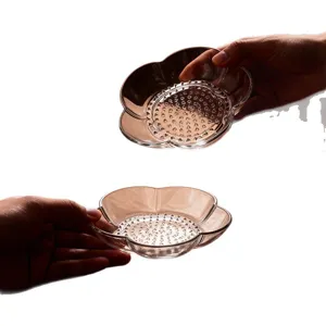 Glass garlic grater dish and condiment plate for household kitchen use, floral shape with grinding teeth.