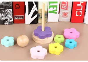 Détail de jouet à empiler en forme de fleur en bois, pièces colorées et base en bois.