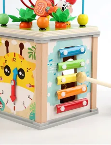Wooden activity cube toy for toddlers, featuring xylophone, clock and bead maze. Detail view.