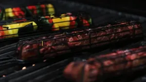 Stainless steel rolling BBQ grill basket for outdoor camping, meat and vegetable cooking tool.
