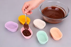 Vista dettagliata dello stampo in silicone con mini pirottini colorati e cioccolato liquido.