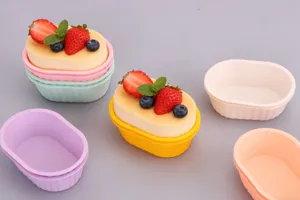 Primo piano di piccoli stampi da forno in silicone ovale con tonalità pastello e costolature.