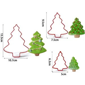 Stainless tree cookie cutter set with decorated biscuit samples and sizes.
