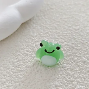 Close-up detail of a cute green frog glass bead, perfect for DIY handmade jewelry crafts.