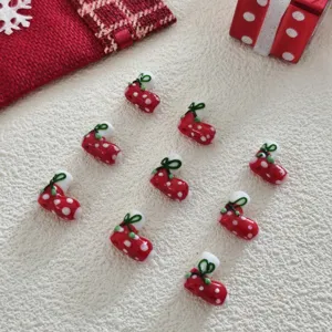 Detailed close-up of handmade Christmas red and white boot glass beads for DIY jewelry and crafts.