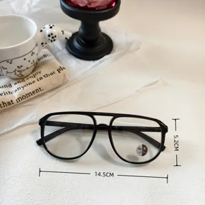 Detail view of vintage double-bridge aviator sunglasses with photochromic lenses in black frame.