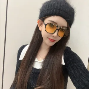 Lunettes de soleil tendance pour femmes avec verres jaunes et élégante monture noire.