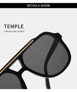 Gros plan sur les branches de lunettes élégantes avec monture noire et barre supérieure dorée.