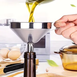 Close-up detail shot of stainless steel kitchen funnel in use, pouring cooking oil neatly.