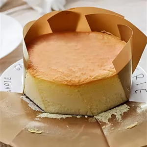 Gâteau rond fraîchement cuit avec emballage en papier sulfurisé sur assiette détail