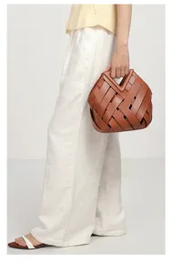 Women vintage woven handbag with unique triangular cutout handle for daily fashion detail look.