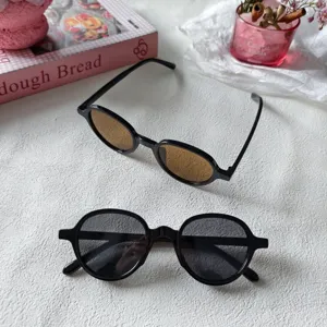 Gafas de sol redondas retro clásicas para mujer, elegante montura negra con lentes tintadas.