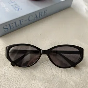 Gafas de sol de ojo de gato vintage Y2K de moda para mujer, detalle montura negra.
