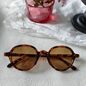 Gafas de sol redondas carey retro con lentes ámbar, vista detallada de estilo streetwear vintage.