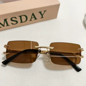 Lunettes de soleil carrées sans monture pour homme avec verres marron et branches dorées.