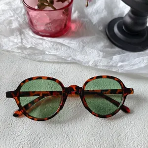 Gafas de sol redondas retro con montura carey y lentes verdes para mujer muy elegantes.